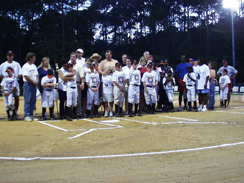Boys Baseball team with coaches and parents lined up on the field