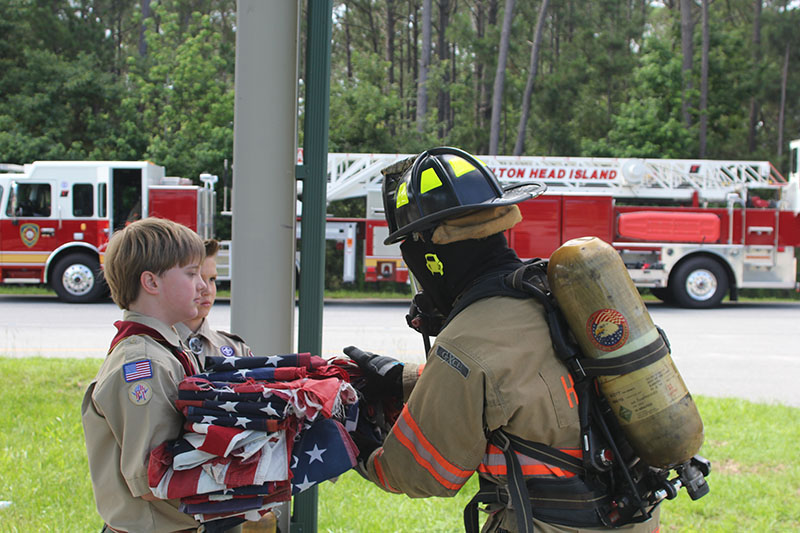 Boy Scouts hand firefighter flags for disposal