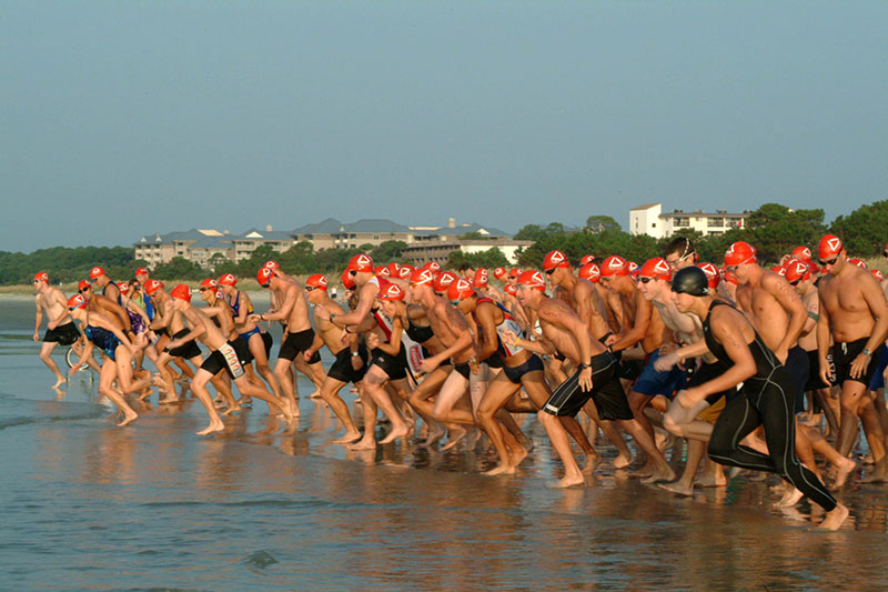 Swimmers running into the water